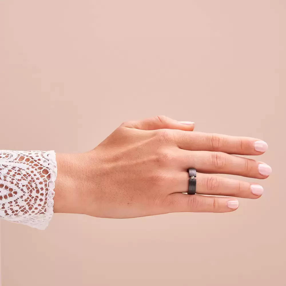 Ehering aus Carbon mit cognacfarbenen Diamanten in Spannfassung auf Hand