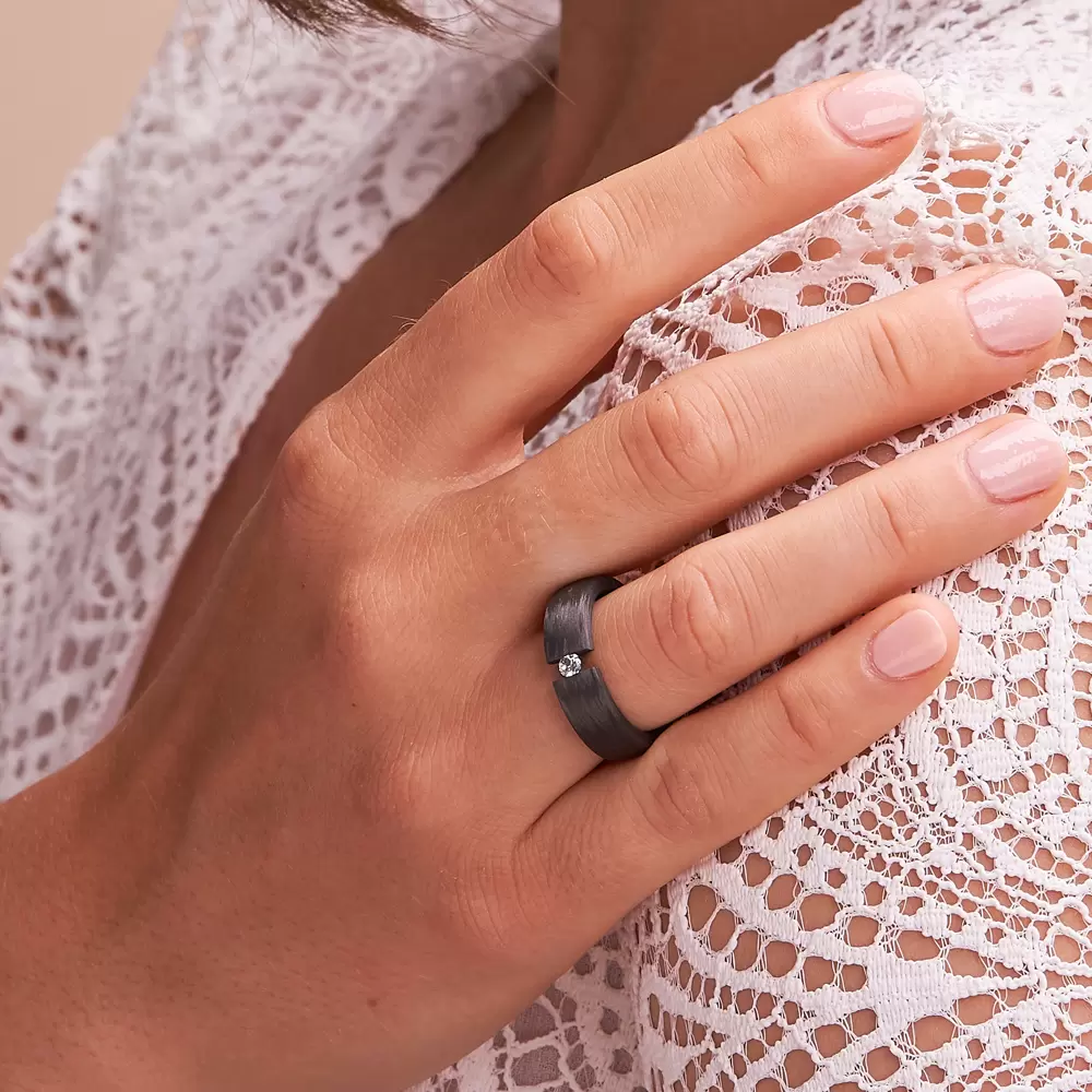 schwarzer Carbon Verlobungsring mit Zirkonia oder Diamanten an Hand an Schulter im Zoom