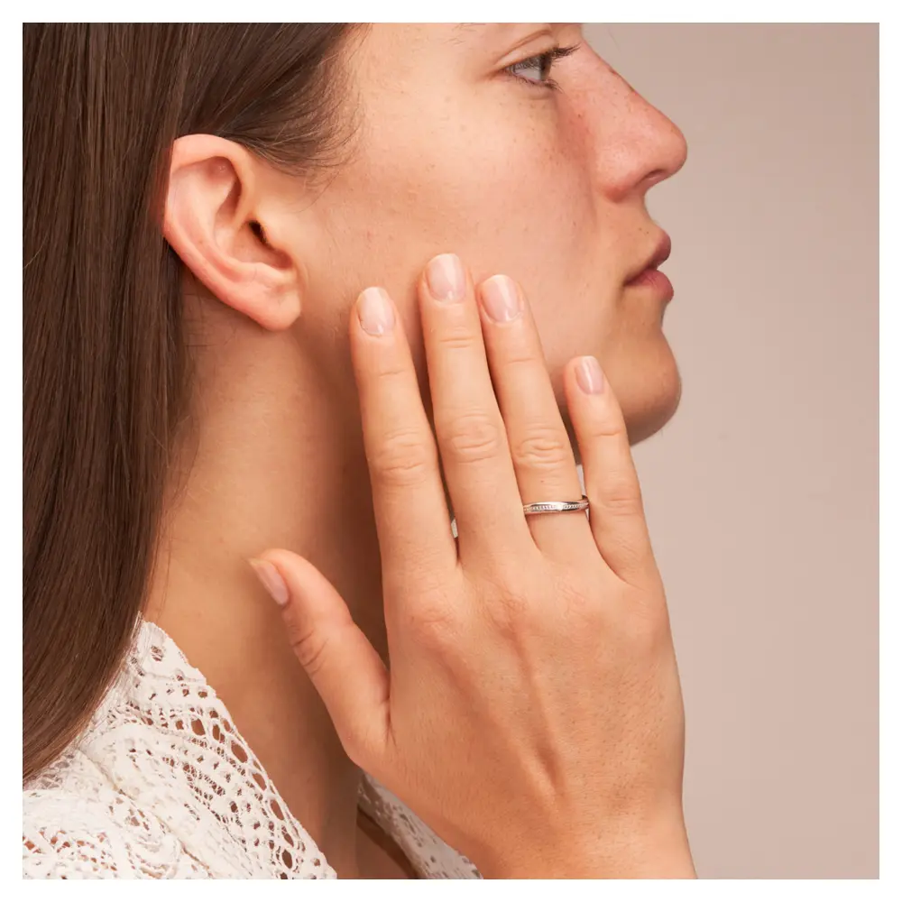 Trauring aus rhodiniertem Silber 925 in asymmetrischer Form mit Diamanten auf Hand am Gesicht