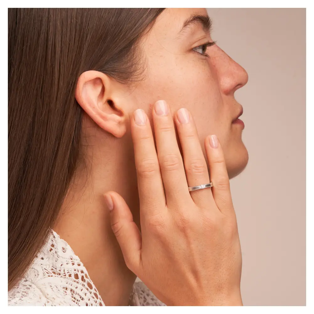 Trauring aus Silber 925 mit Labor-Diamanten und Millgriff auf Hand im Gesicht