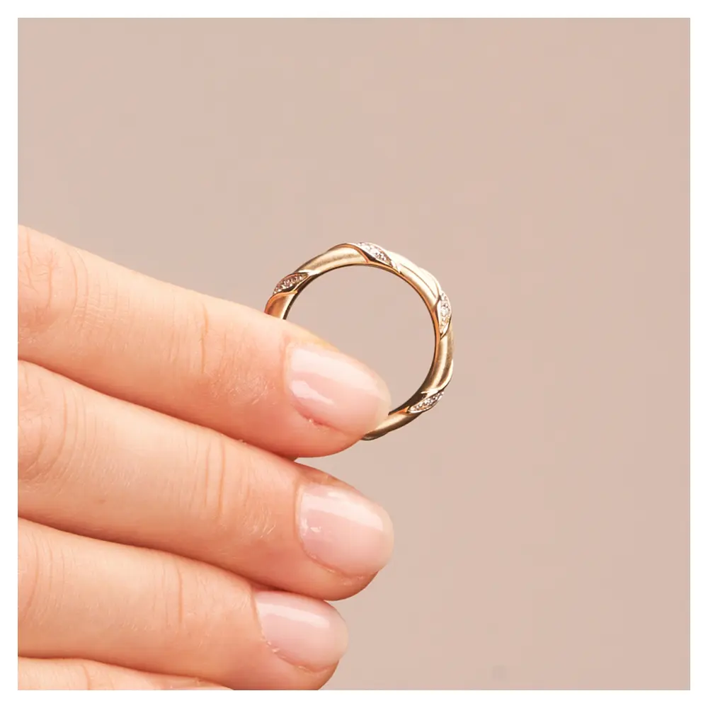 Quermatte Trauringe aus vergoldetem Silber 925 mit Diamanten in Hand im Profil