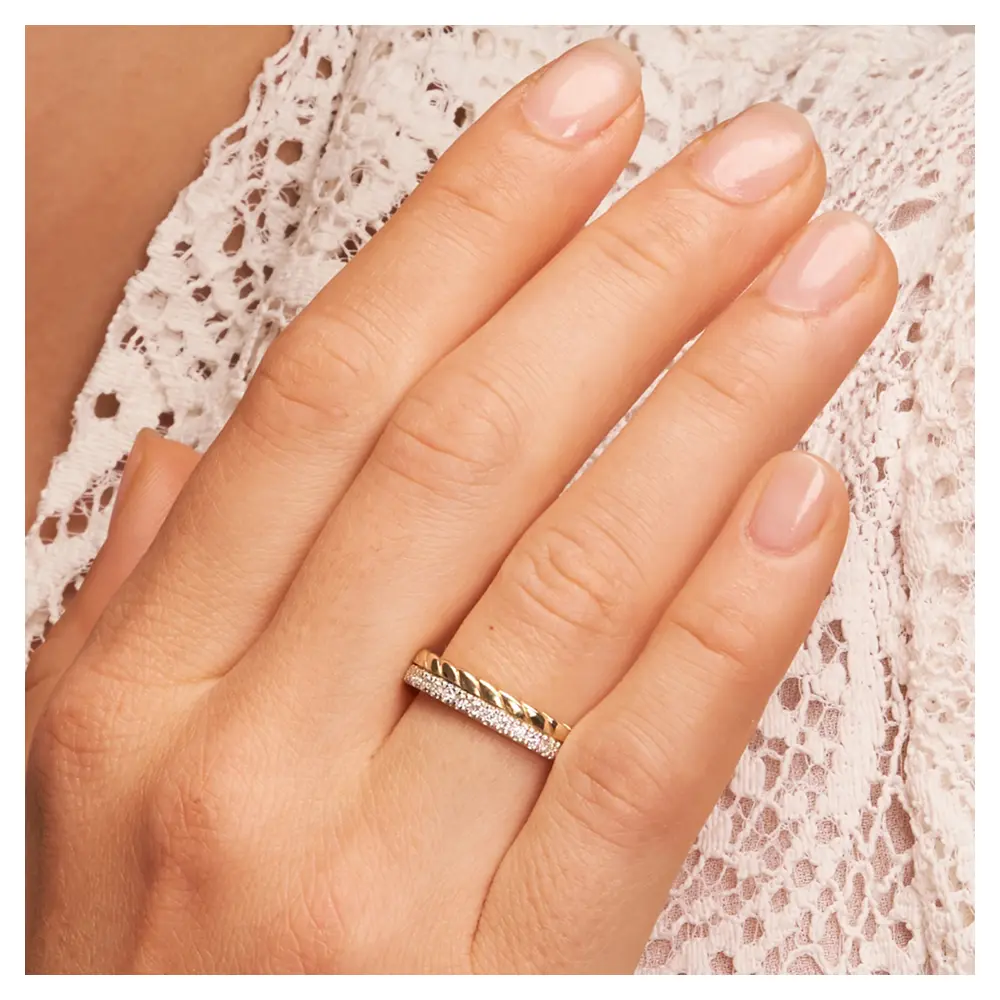 Trauringe aus Silber 925 mit Vergoldung und Band aus Labor-Diamanten auf Hand im Gesicht im Zoom