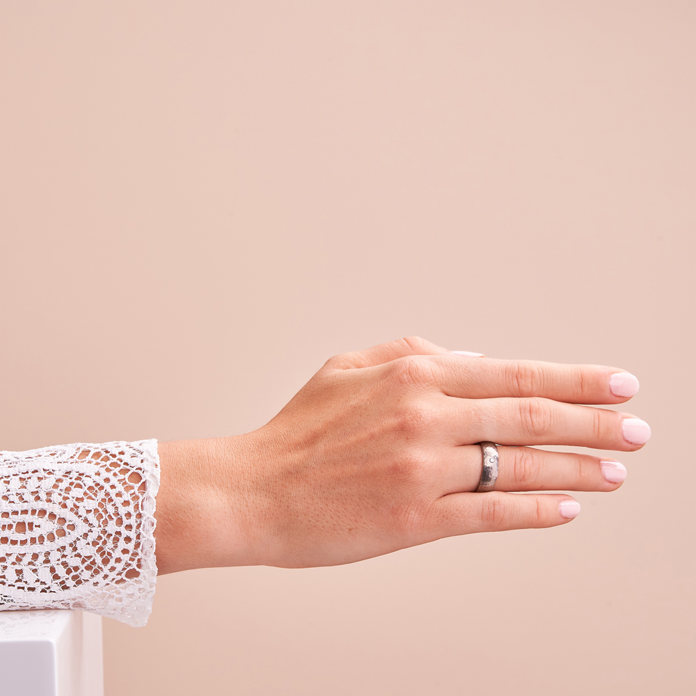 Aufnahme von gehämmerten Trauringen aus Titan mattiert mit Diamanten auf Hand