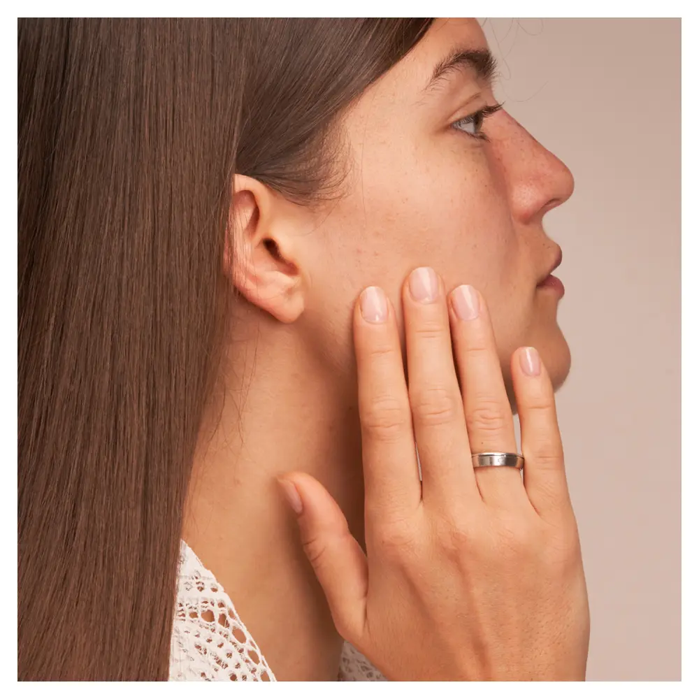 Trauringe aus platiniertem Silber 925 mit Diamanten und seitlicher Rille auf Hand am Gesicht