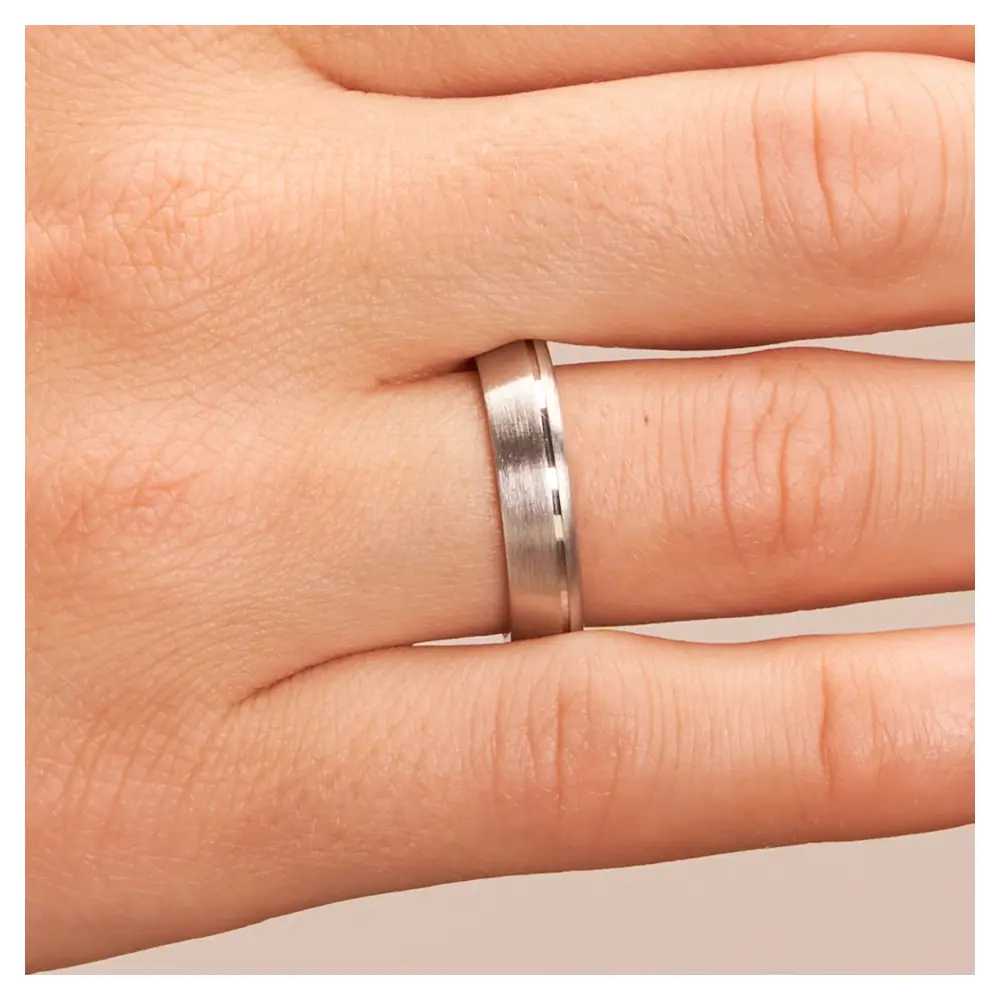 Trauringe aus platiniertem Silber 925 mit seitlicher Rille auf Hand im Zoom