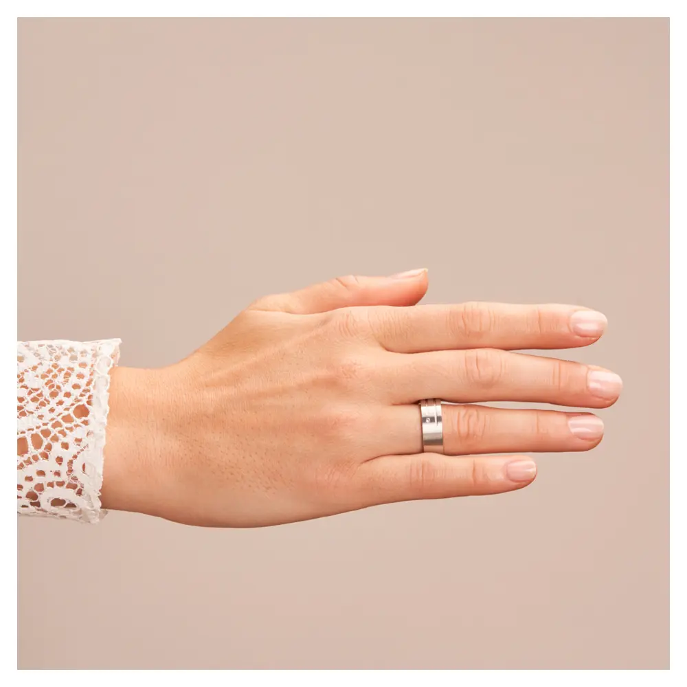 Breite Trauringe aus Silber 925 platiniert mit Diamanten und Rillen auf Hand