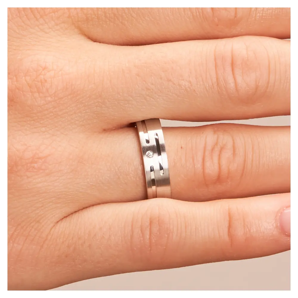 Eheringe aus platiniertem Silber 925 mit Rillenmuster und Diamanten auf Hand im Zoom