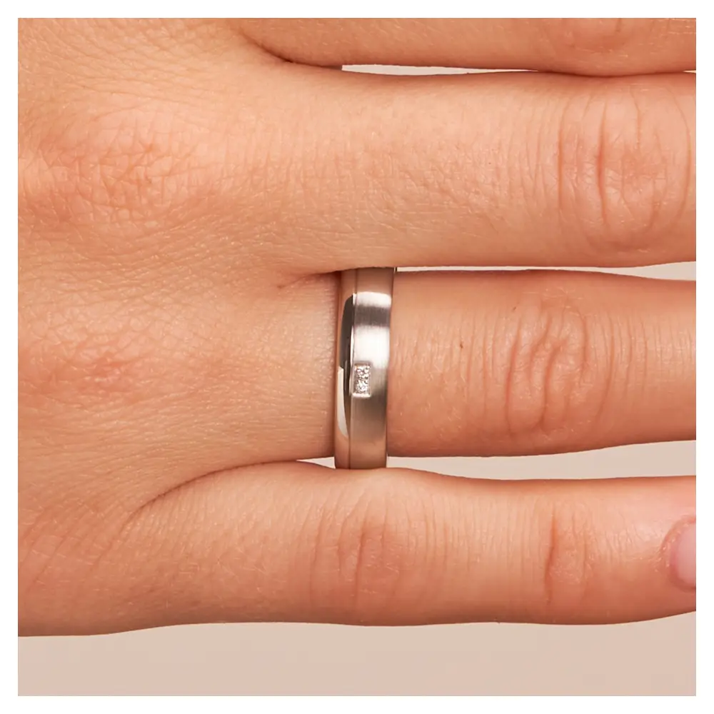 Trauringe aus rhodiniertem Silber 925 in Längsmattierung und zwei Diamanten auf Hand im Zoom