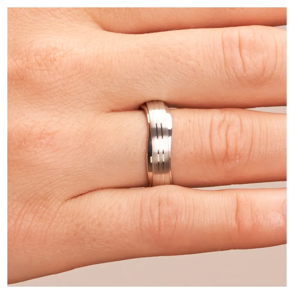 Trauringe aus platiniertem Silber 925 im wellenförmigen Design auf Hand im Zoom