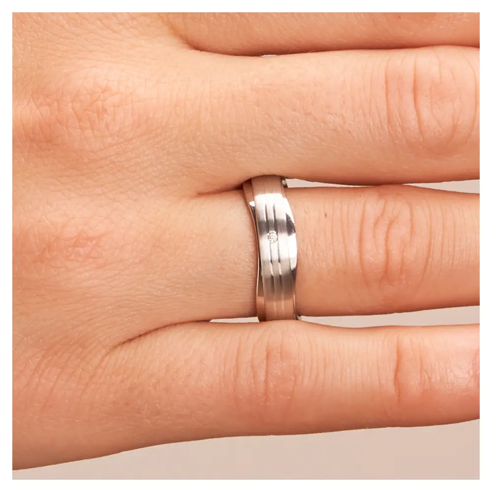 Trauringe aus platiniertem Silber 925 im wellenförmigen Design mit Diamanten auf Hand im Zoom