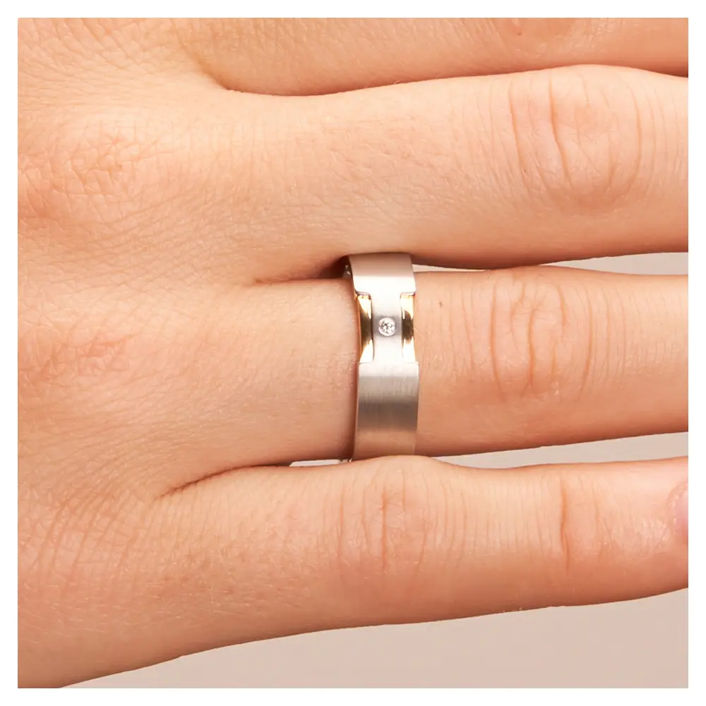 Trauringe aus platiniertem Silber 925 mit 14K Gelbgold Rillen und Diamanten auf Hand im Zoom