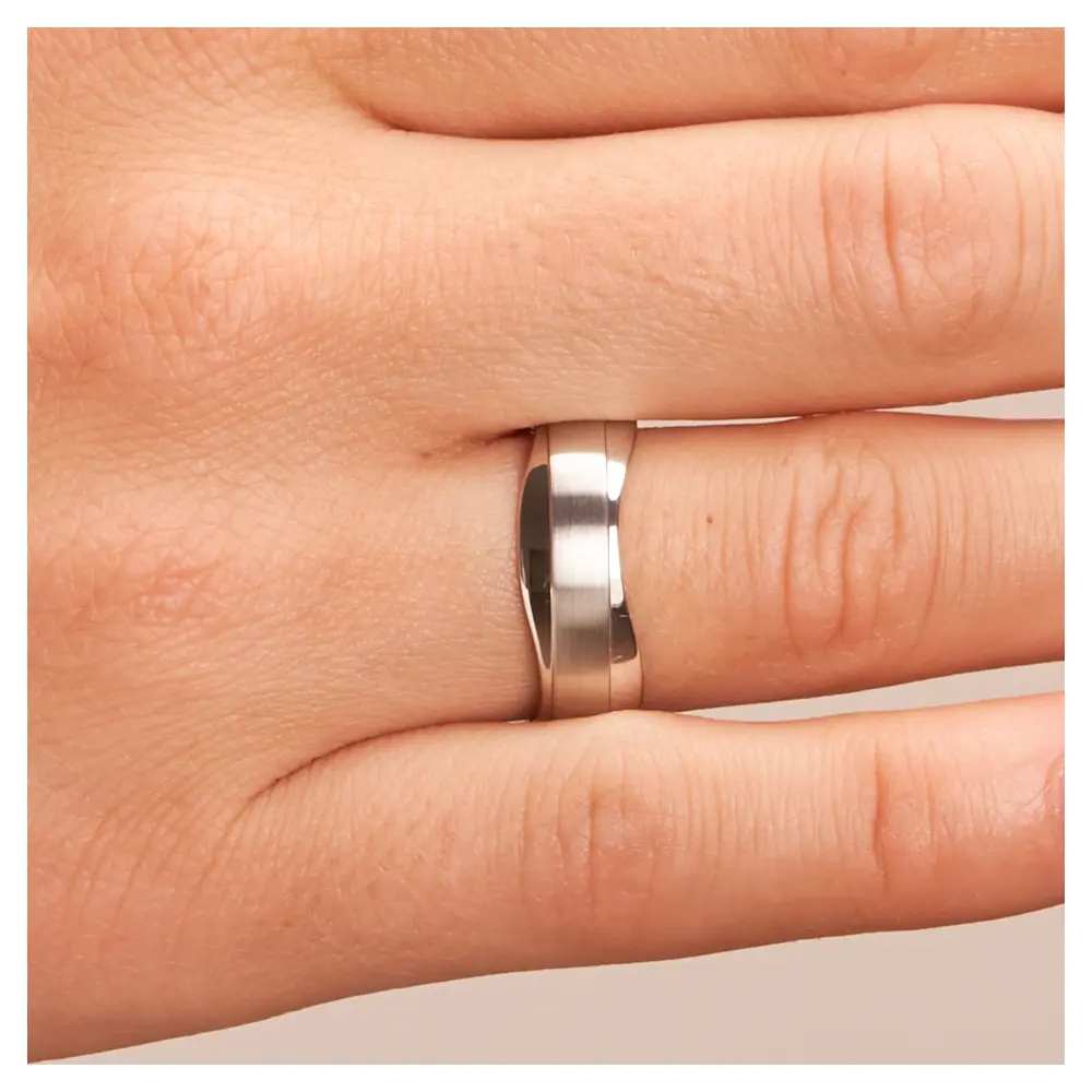 Trauringe aus Silber 925 platiniert mit welligem Rand auf Hand im Zoom