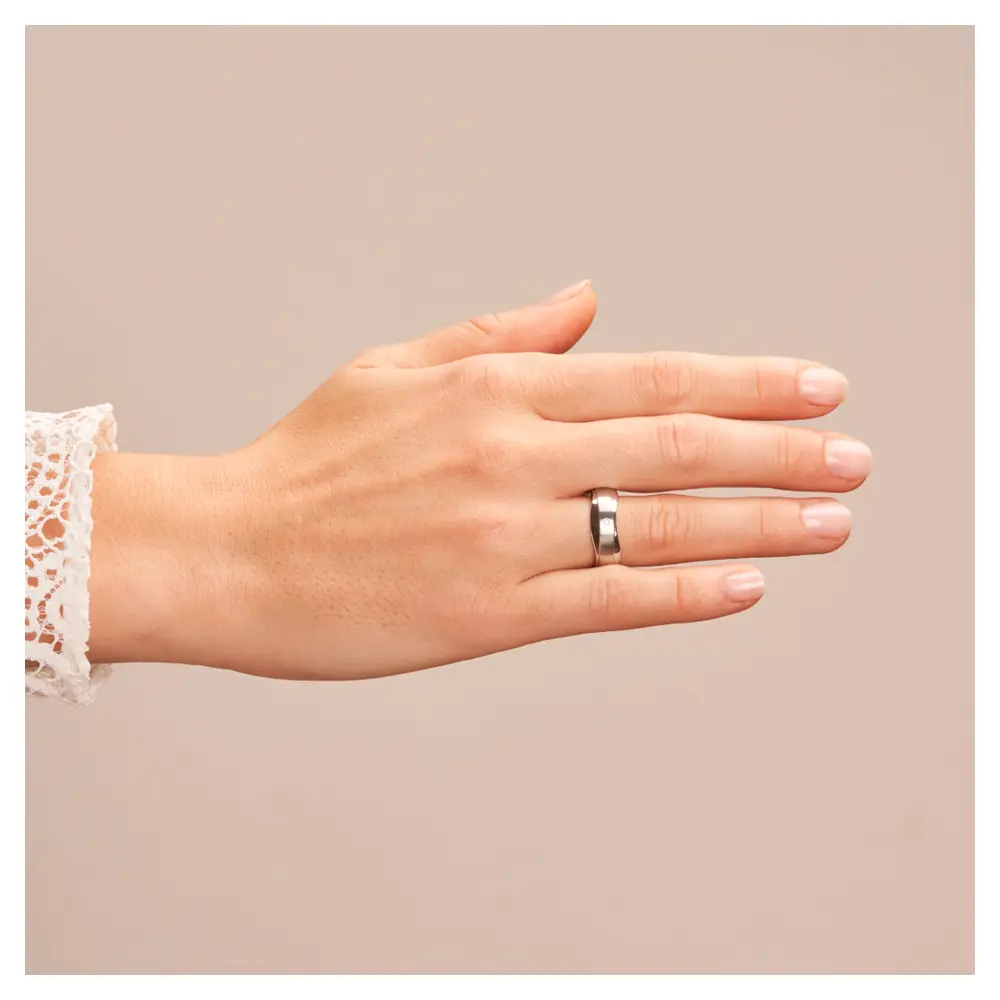 Trauringe aus Silber 925 platiniert mit welligem Rand und Diamant auf Hand