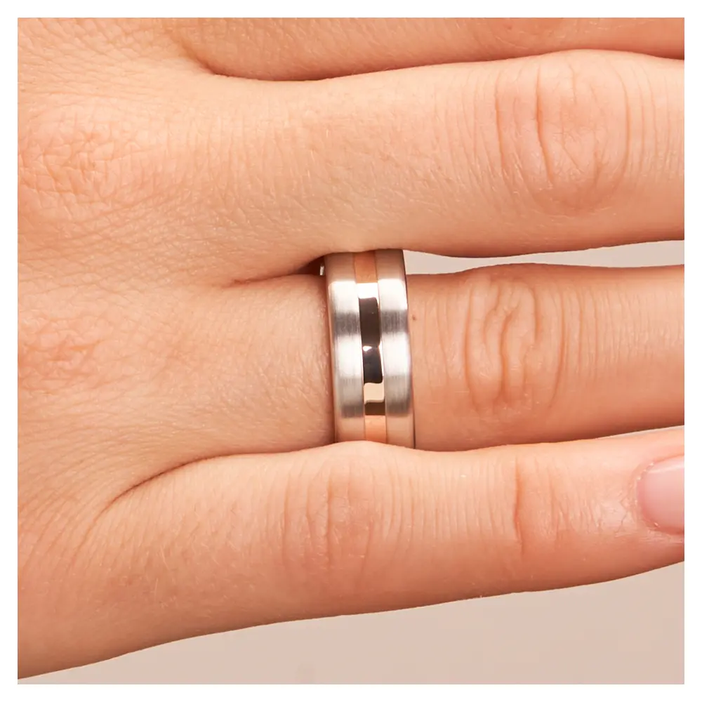 Trauringe aus Silber 925 platiniert mit Rotgold 14K Streifen auf Hand im Zoom