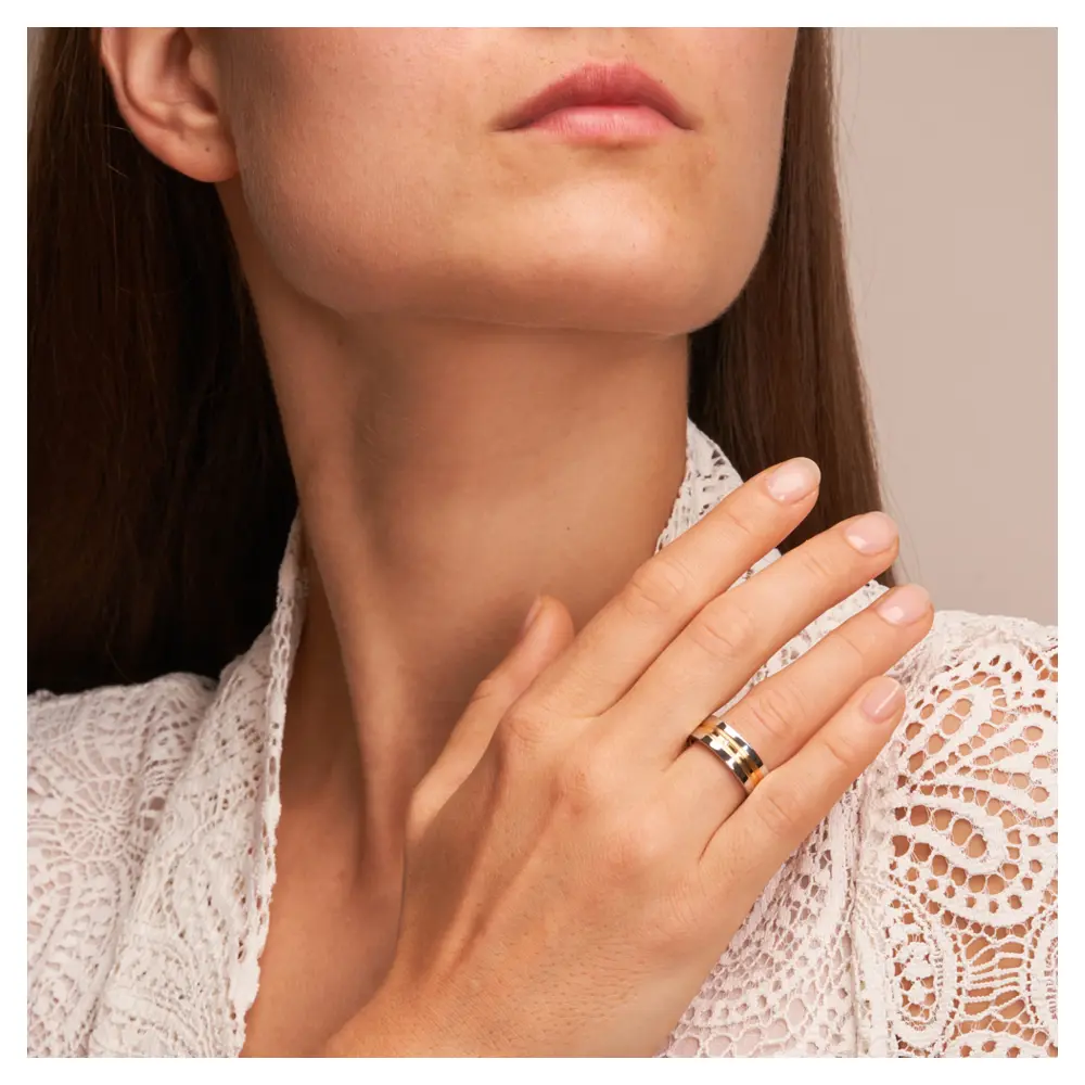 Trauringe aus Silber 925 platiniert mit 14K Gelbgold und Diamanten auf Hand am Gesicht