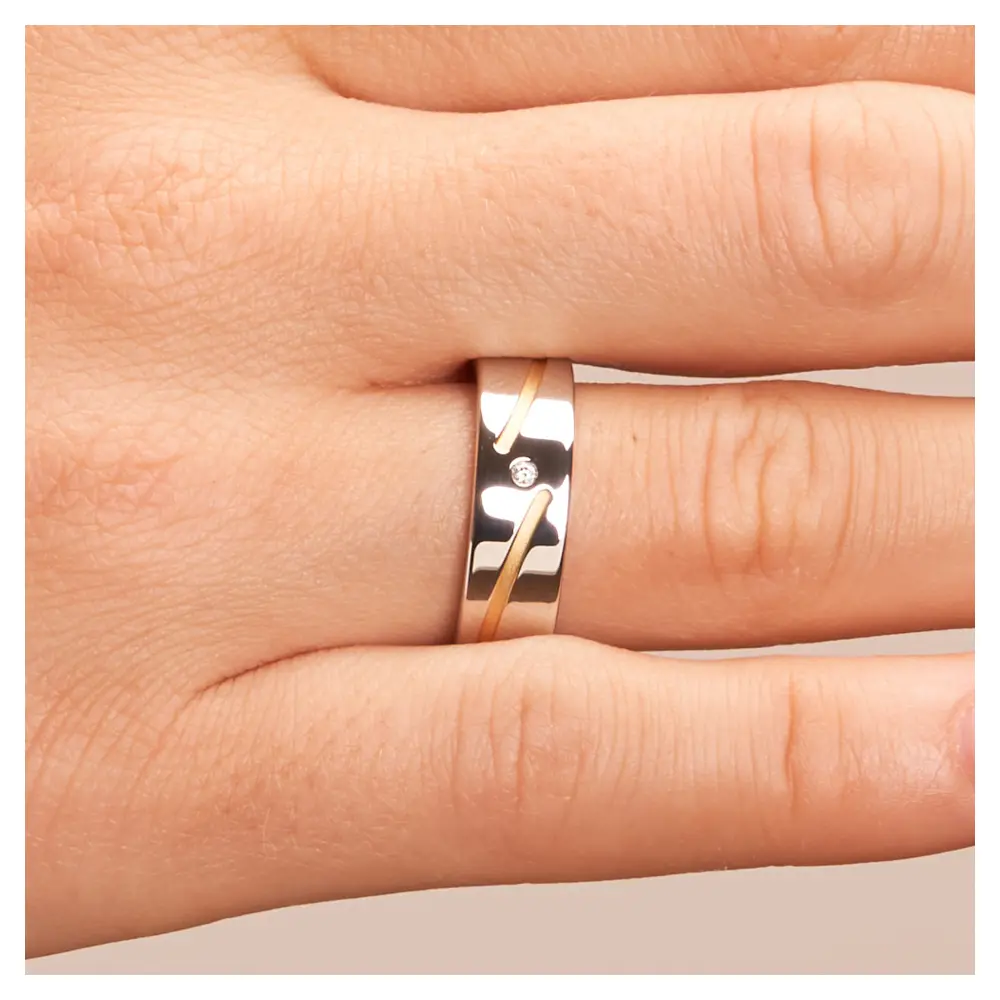 Trauringe aus platiniertem Silber 925 mit 14K Gelbgold in Rillen und Diamanten auf Hand im Zoom