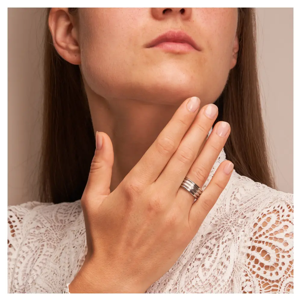 Eheringe breit und plastisch aus platiniertem Silber 925 mit Diamanten auf Hand am Gesicht