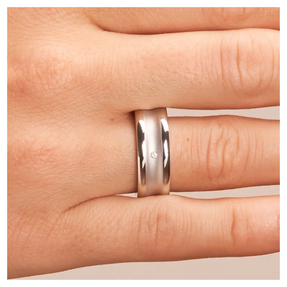 Trauringe aus platiniertem Silber 925 in konkaver Form matt mit Diamanten auf Hand im Zoom