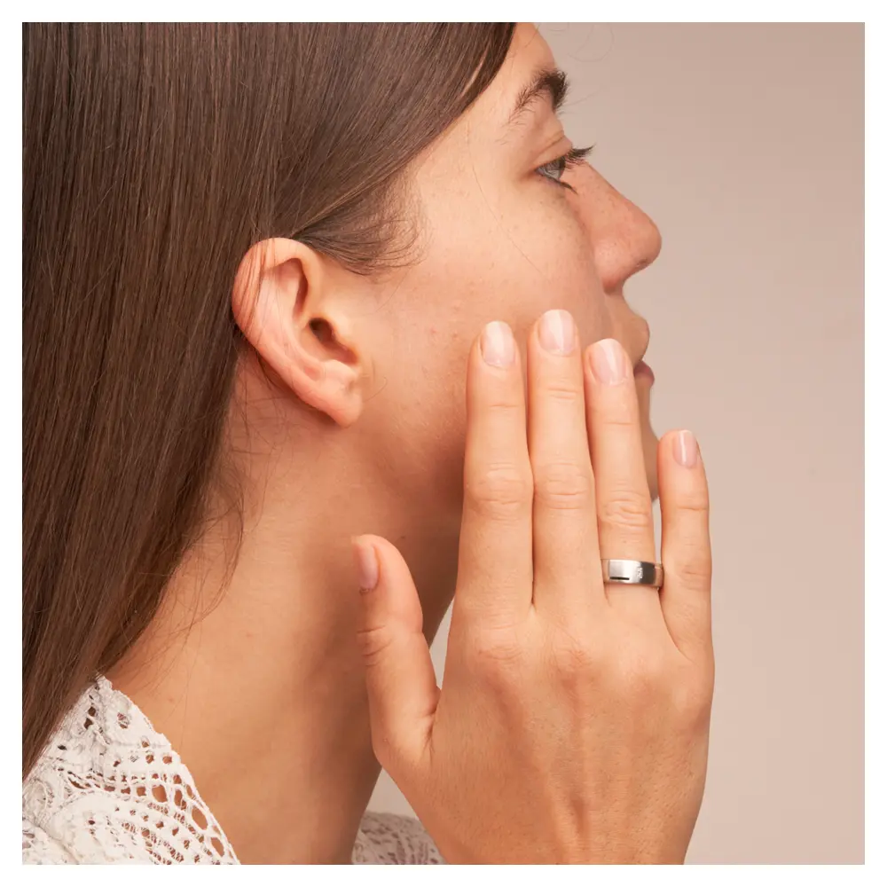 Matte Eheringe aus platiniertem Silber 925 mit zwei Diamanten und Rillen auf Hand am Gesicht