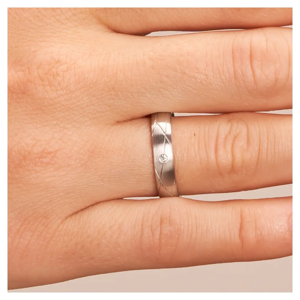 Eheringe aus Silber 925 platiniert mit kreuzverlaufenden Rillen und Diamanten auf Hand im Zoom