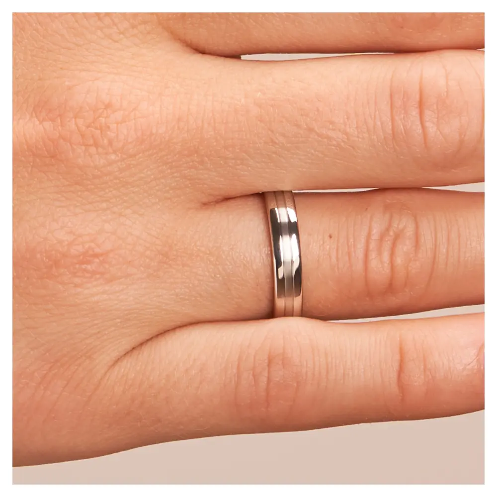 Trauringe aus Silber 925 platiniert mit polierten Rändern auf Hand im Zoom