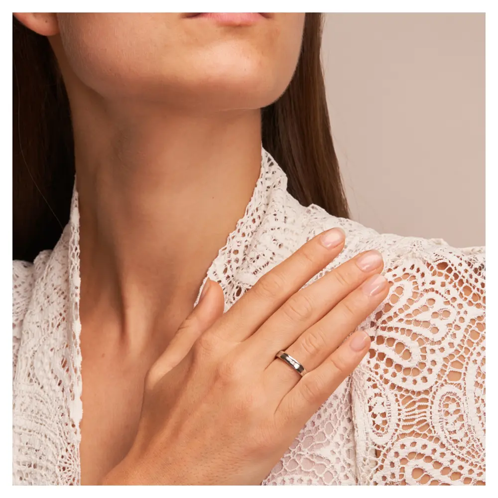 Trauringe aus Silber 925 platiniert mit polierten Rändern und Diamanten auf Hand am Gesicht