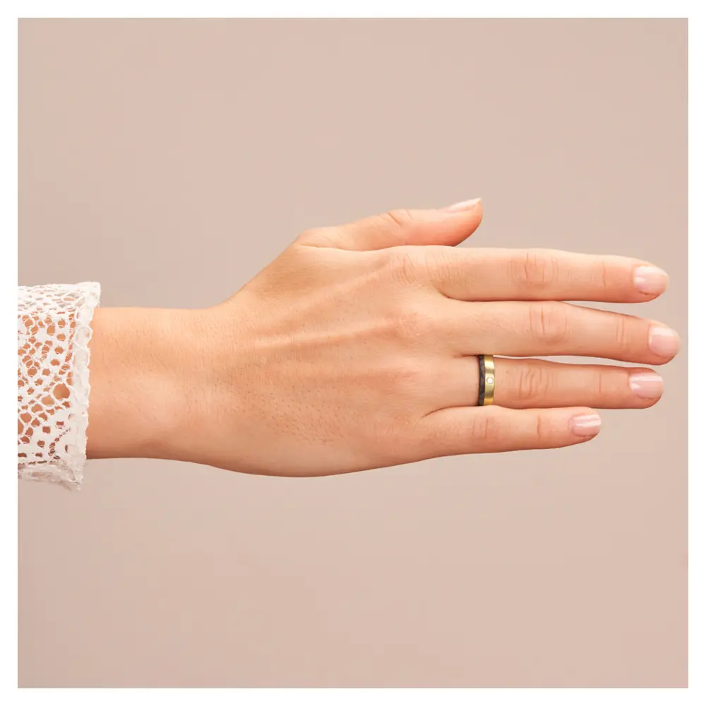 Eheringe aus Gelbgold mit Carbonstreifen und Diamanten auf Hand