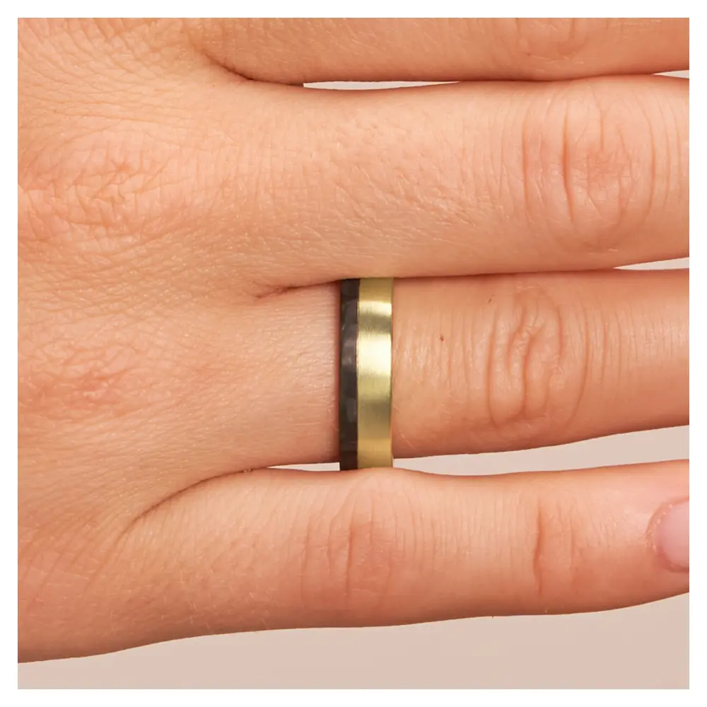 Eheringe aus Gelbgold mit Carbonstreifen auf Hand im Zoom