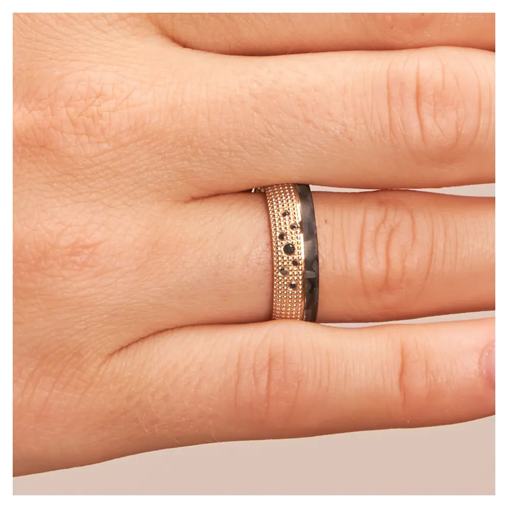 Eheringe aus Roségold und gemasertem Carbon mit schwarzen Diamanten auf Hand im Zoom