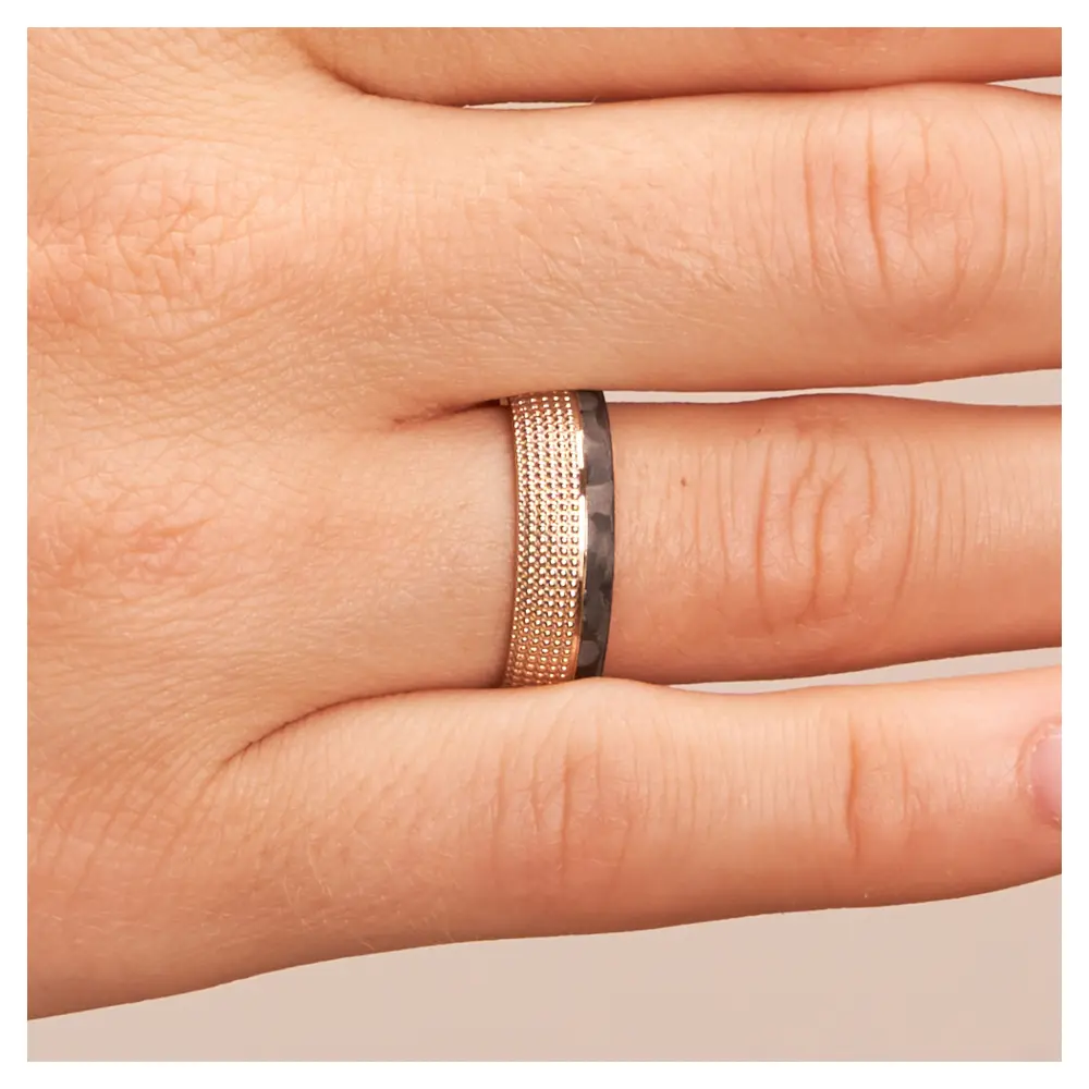 Eheringe aus Roségold und gemasertem Carbon auf Hand im Zoom