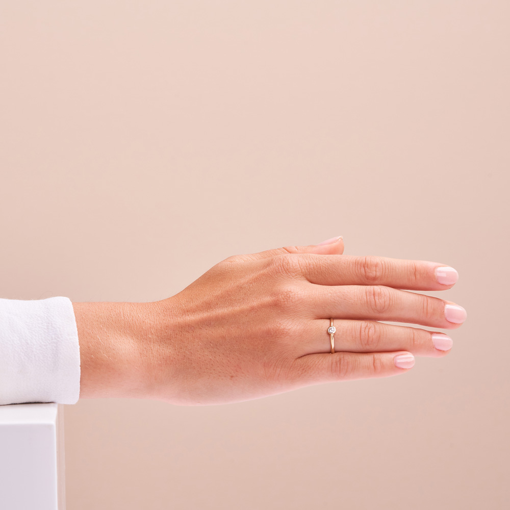 Aufnahme vom Schmuckring aus Gelbgold 585 mit Zirkonia in Zargenfassung auf Hand 