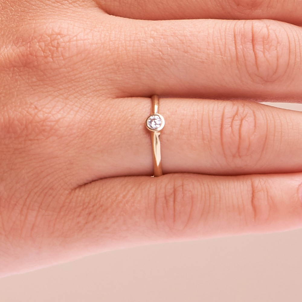 Aufnahme vom Schmuckring aus Gelbgold 585 mit Zirkonia in Zargenfassung auf Hand 