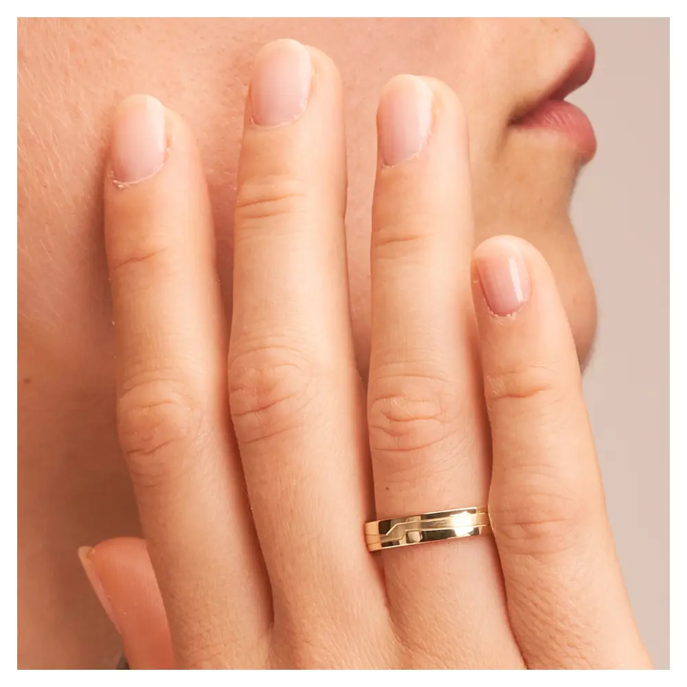 Gelbgold Eheringe schmal mit geometrischen Rillen auf Hand im Zoom