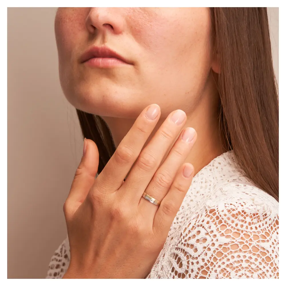 Trauringe aus Gelbgold und Weißgold mit Mattierung und 2 schrägen Rillen und Diamant auf Hand