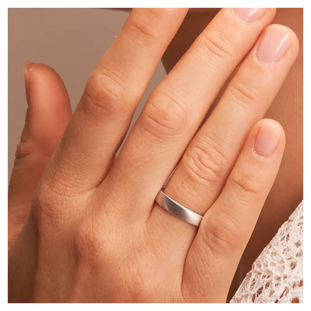 Eheringe aus Platin quermatt auf Hand im Zoom