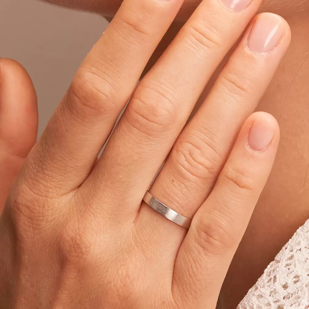Längsmatte 3 mm breite Weißgold Eheringe auf Hand im Zoom