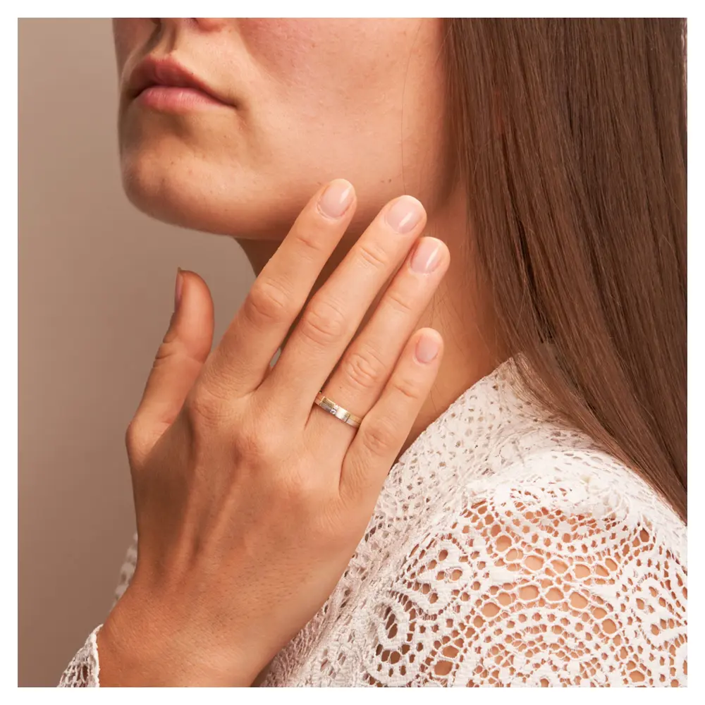 Trauringe aus Gelbgold und Weißgold mattiert mit 2 Diamanten und Rillen auf Hand