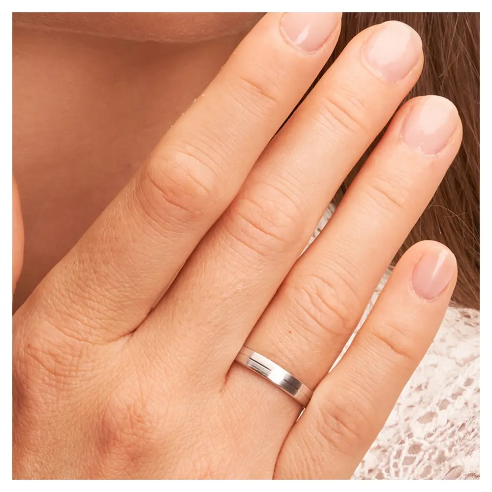 Mattierte Eheringe aus Platin auf Hand im Zoom