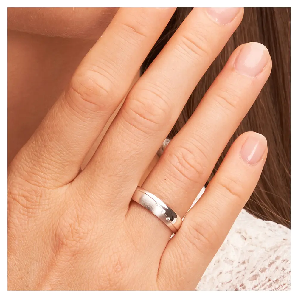 Trauringe aus Weissgold mit 3 Diamanten und Polierung und Mattierung und Rille auf Hand im Zoom