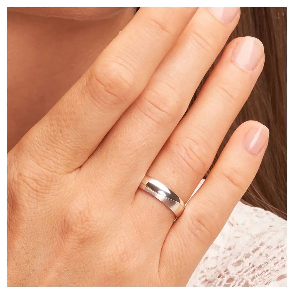 Trauringe aus Weissgold mit Polierung und Mattierung und Rille auf Hand im Zoom