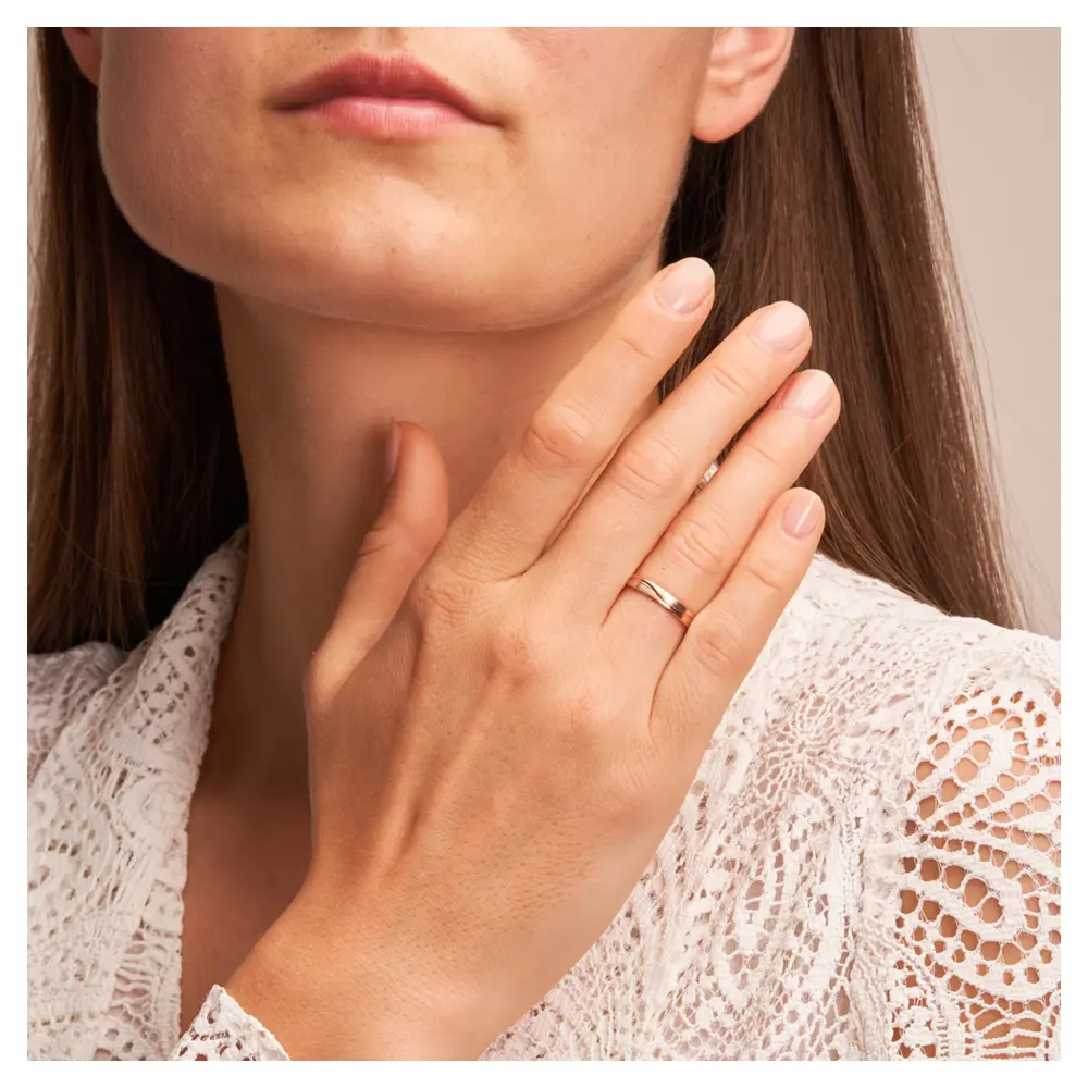 Trauringe aus Roségold mit Mattierung und geschwungenen Rillen auf Hand