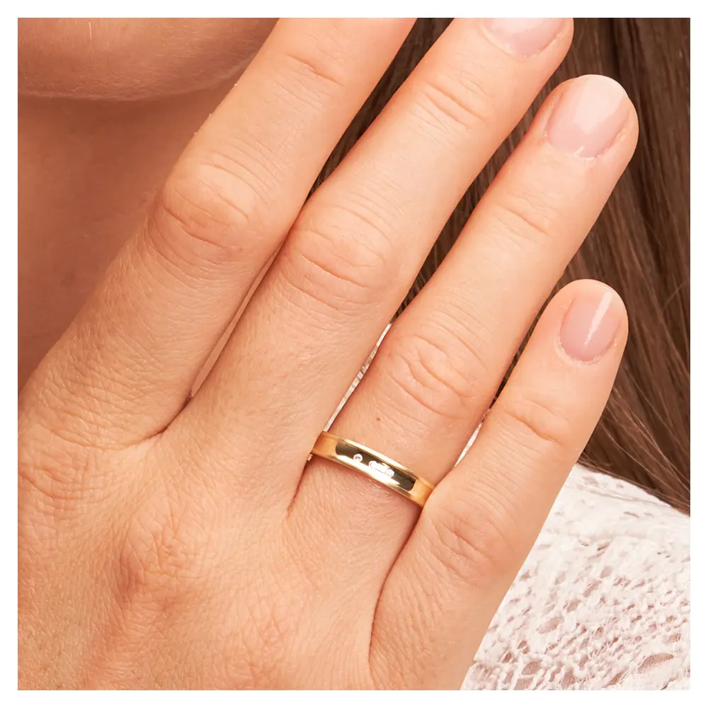 Trauringe aus Gelbgold poliert mit konkaver Form mit drei Diamanten auf Hand im Zoom