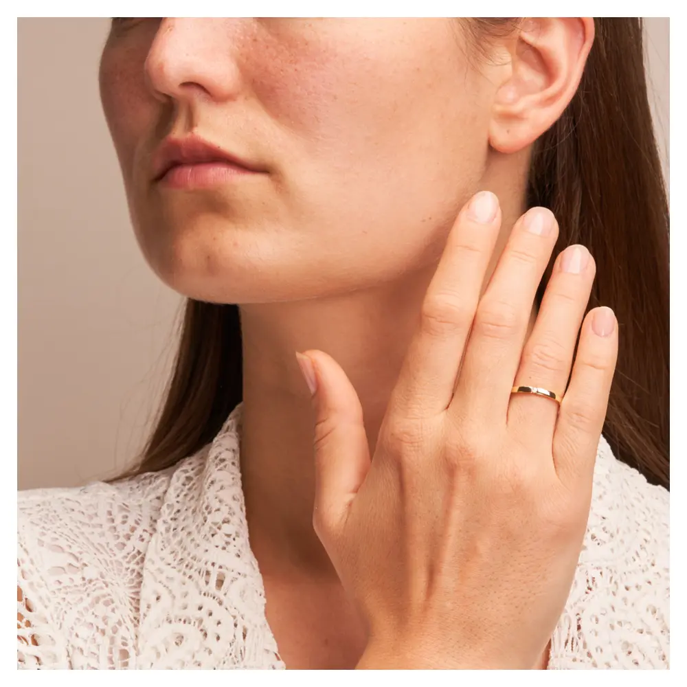 Trauring aus Gelbgold mit Polierung und flachem Profil und Diamant auf Hand