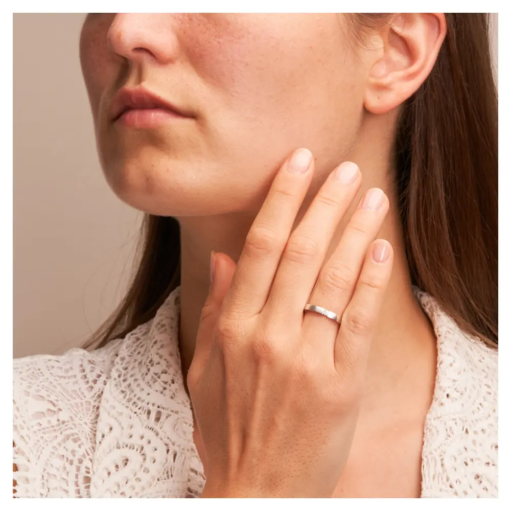 Ehering aus Weissgold längsmatt flach mit Diamanten auf Hand