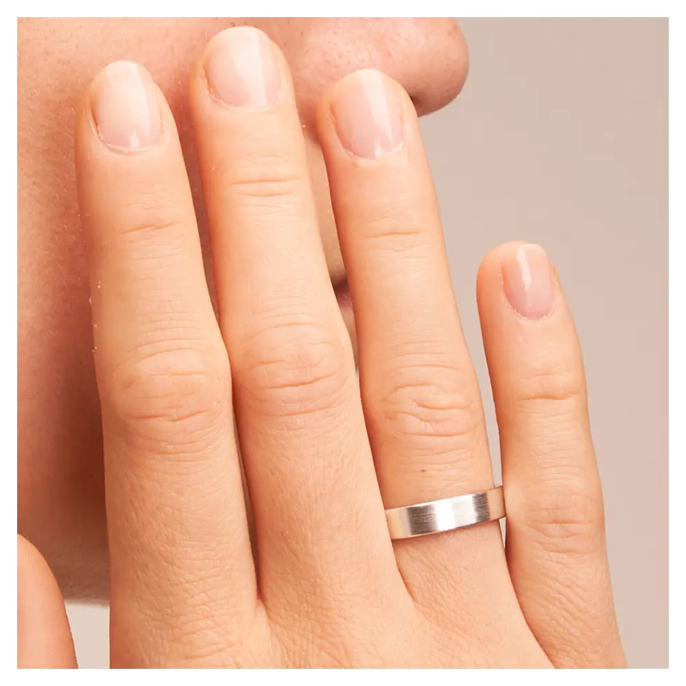 Mattierte Eheringe aus Weissgold auf Hand im Zoom