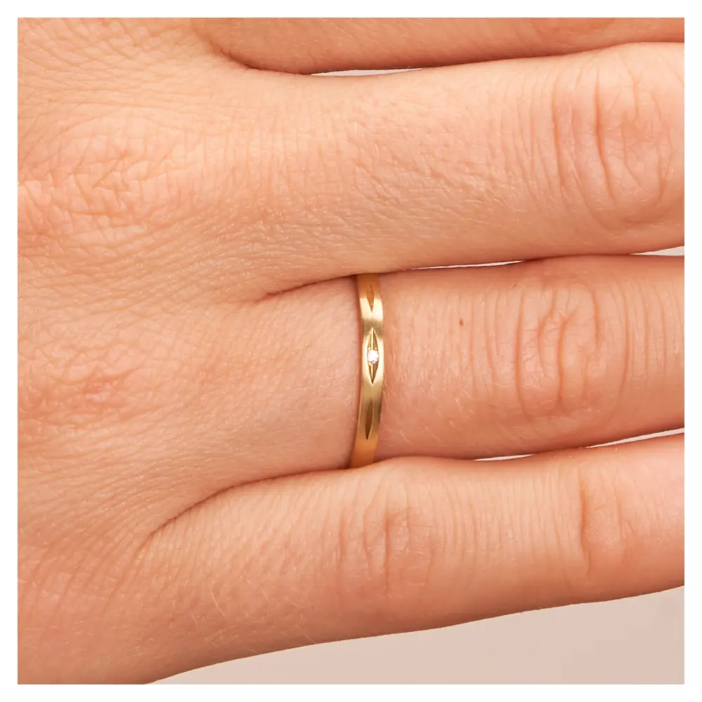 Eheringe aus längsmattem Gelbgold mit Diamanten in ovaler Vertiefung auf Hand im Zoom