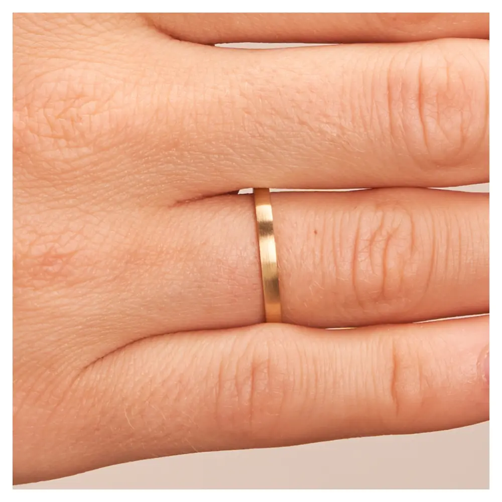 Eheringe aus längsmattem Gelbgold auf Hand im Zoom