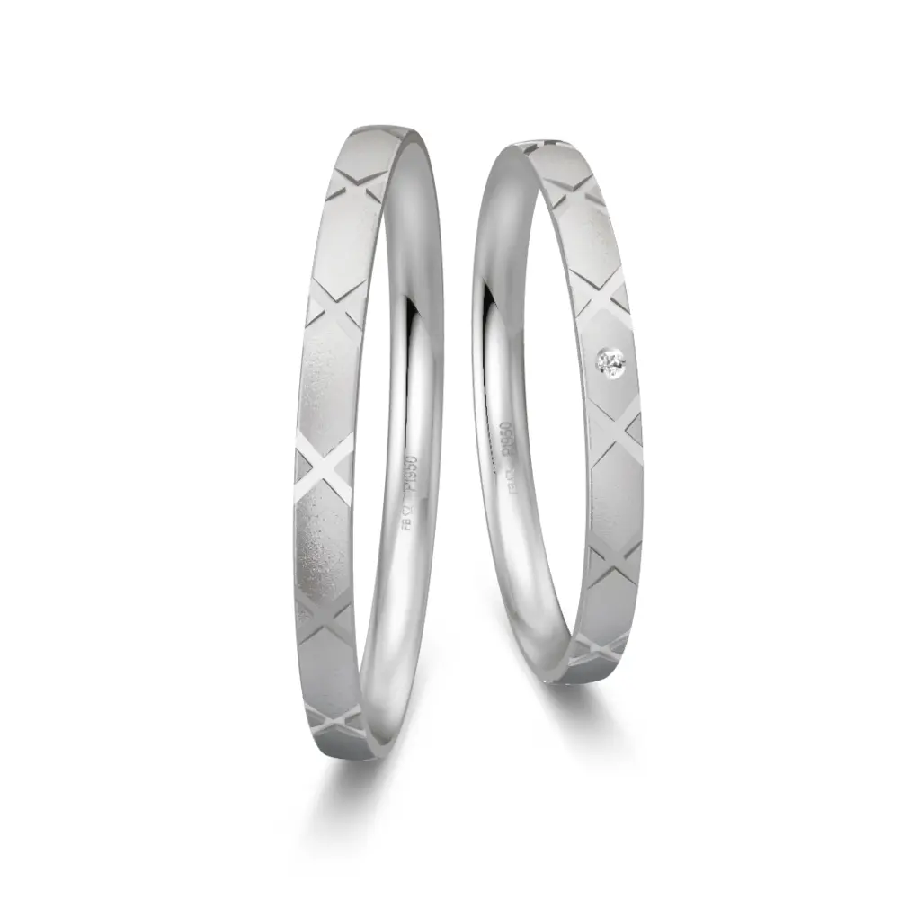 Sandmattierte Eheringe aus Platin mit Muster und Diamanten