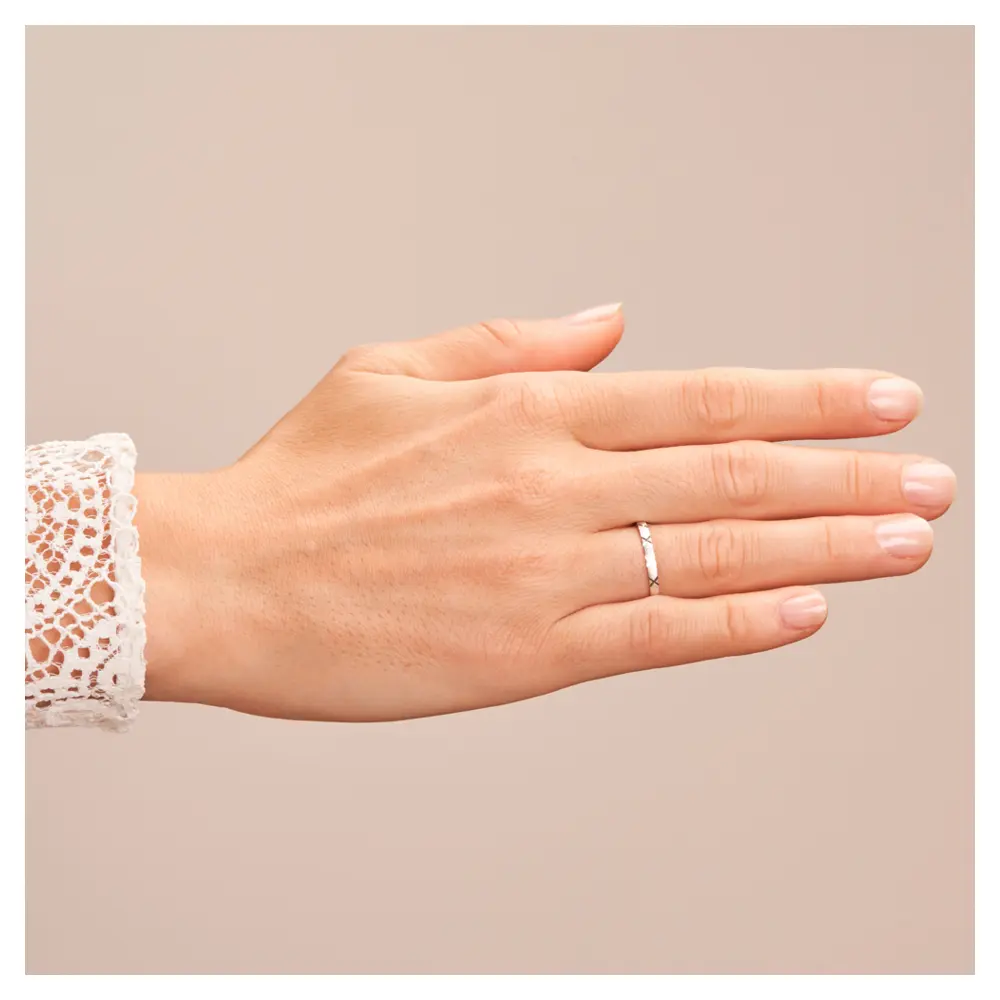 Ehering aus Weißgold sandmatt mit Diamanten und Kreuzmuster auf Hand