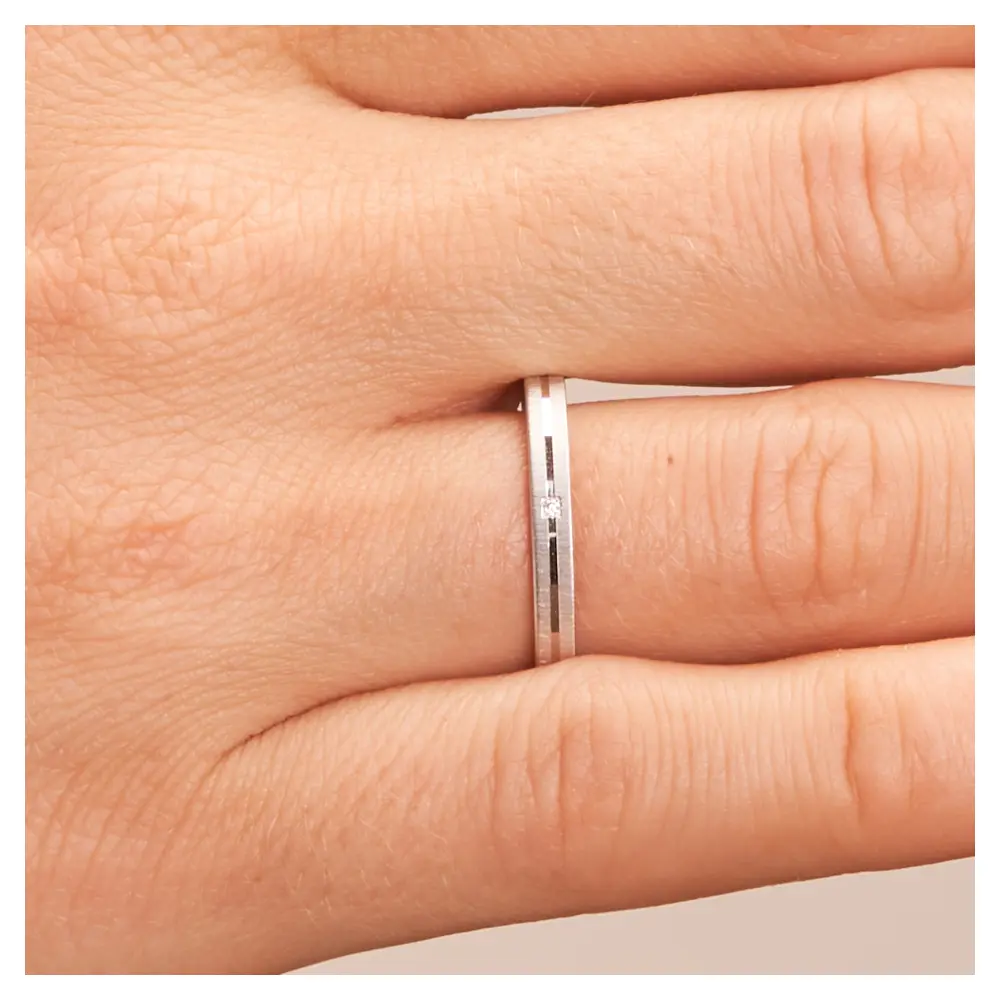 Ehering aus Platin mit Quermattierung und Diamanten in Rille auf Hand im Zoom